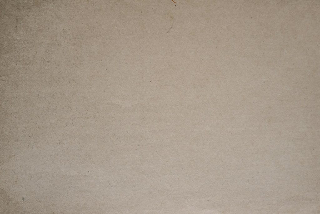 a brown paper background with a black and white cat sitting on top of it