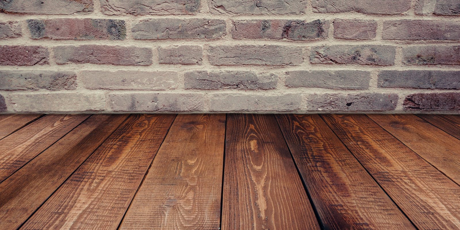 Stylish vintage brick wall background complemented by a rustic wooden floor.