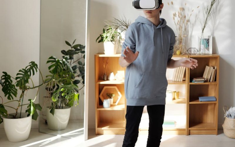 Teenager wearing VR headset enjoying virtual reality experience indoors.