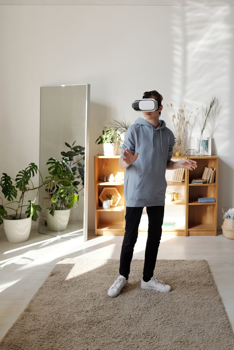 Teenager wearing VR headset enjoying virtual reality experience indoors.