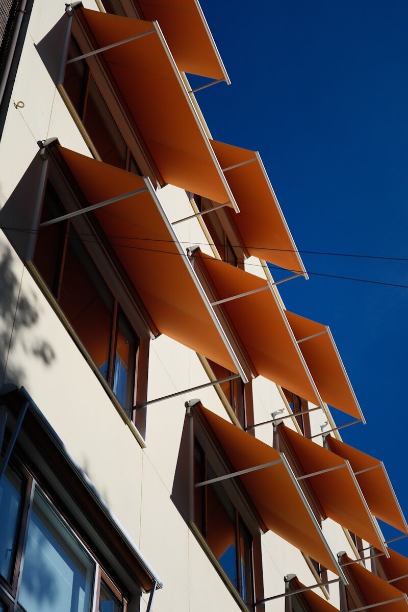 Modern building with orange awnings against blue sky